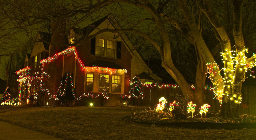 Home outlined in warm white Christmas lights at night