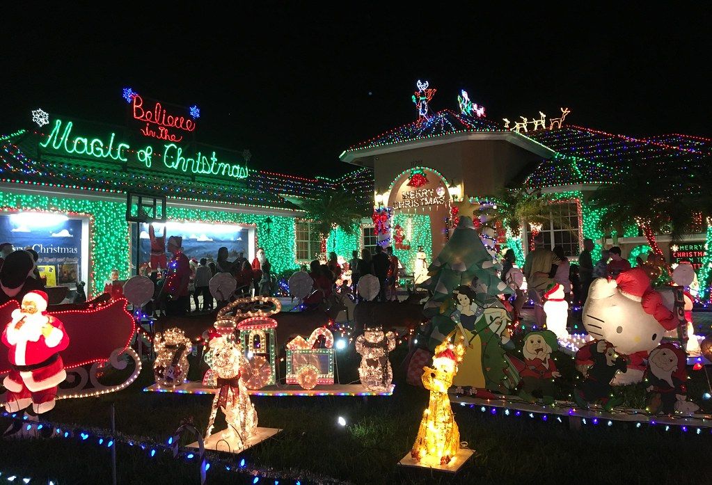 Brightly lit house with Santa and a holiday yard display at night